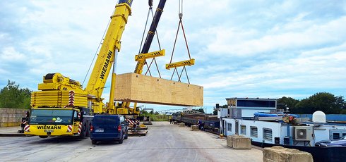 Kranwagen verlädt Container auf ein Schiff